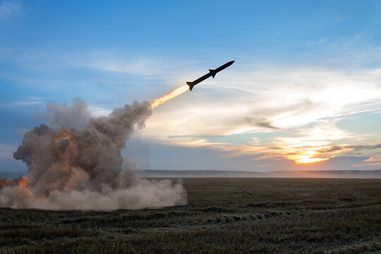 Launching a rocket from a rocket launcher in the fields. Concept: war in Ukraine, missile attack, Russian nuclear threat.