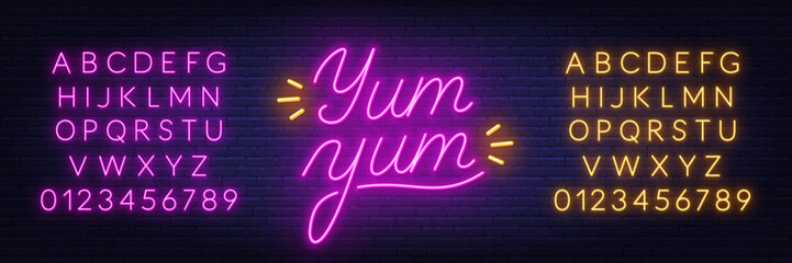 Yum Neon Sign on brick wall background.