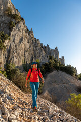 Woman backpacker on the hiking path to Frares de Serrella mountain range on Costa Blanca,...