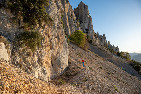 Woman backpacker on the hiking path to Frares de Serrella mountain range on Costa Blanca, Quatretondeta , Alicante, Spain - stock photo