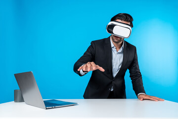 Professional project manager looking by using VR goggle while sitting at laptop. Skilled business...