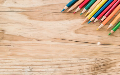 Obraz premium photo of a light-colored desk seen from above, with scattered colored pencils on it