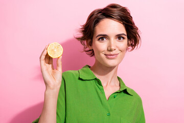 Photo portrait of pretty young girl hold half lemon fruit wear trendy green outfit isolated on pink color background