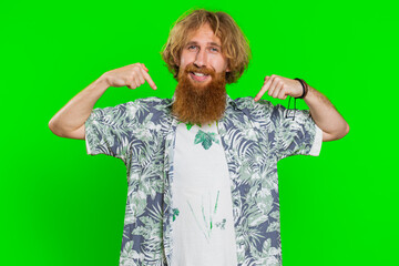 I am the best, choose me. Young happy man feeling very proud pointing herself, looking self-confident, overjoyed by success, making choice. Redhead adult guy isolated on green chroma key background