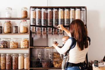 Mother and Child Selecting Nuts at a Zero-Waste Store During Daytime Shopping.
