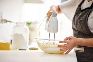 Bowl, hands and mixer for baking with person in kitchen of home closeup for pastry preparation....