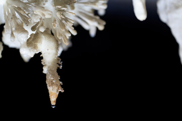Magnificent Stalactite Formation with Water Drop in Dark Cave