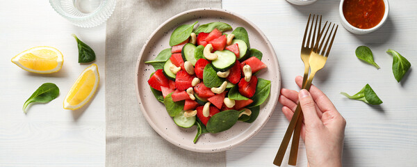 Fresh watermelon salad in a bowl with lemon and strawberries on the table