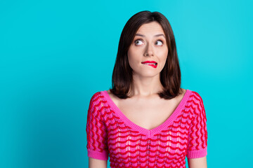 Photo of worried confused woman with straight hairdo dressed knitwear top biting lips look empty space isolated on blue color background