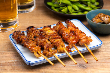 居酒屋のテーブルに並んだ焼き鳥と料理とビール