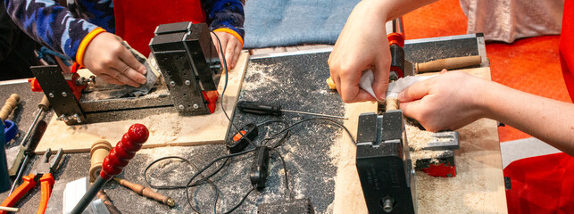 Kids learning wood carving. young carpenter working in a workshop