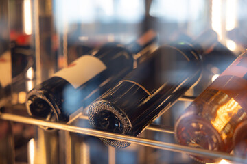 A row of wine bottles on a shelf in Wine cooler.