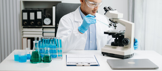 Scientist mixing chemical liquids in the chemistry lab. Researcher working in chemical laboratory.