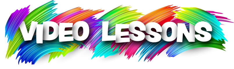 Video lessons paper word sign with colorful spectrum paint brush strokes over white.