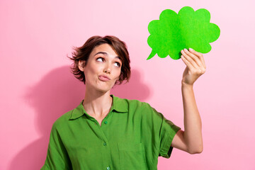 Photo portrait of pretty young girl hold look skeptical comics paper cloud wear trendy green outfit isolated on pink color background