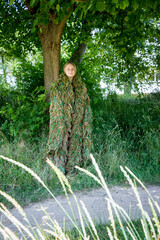volunteer woman in a camouflage suit made of multi-colored threads, handmade, help to the military, Ukraine
