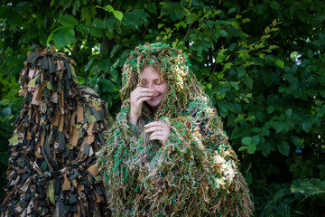 volunteer woman in a camouflage suit made of multi-colored threads, handmade, help to the military,...