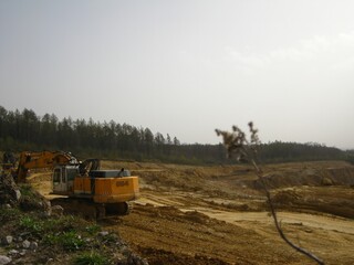 Yellow excavator at limestone mining site 