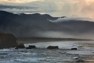 Ocean beach cliffs and mist in New Zealand