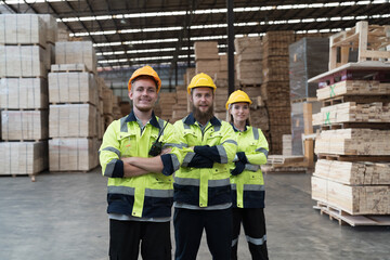 Group of male and female warehouse workers standing together with crossed arms and smiling in...
