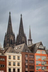 View of old colorful houses and the Roman Catholic Gothic Cathedral Kolner Dom in Cologne, Germany