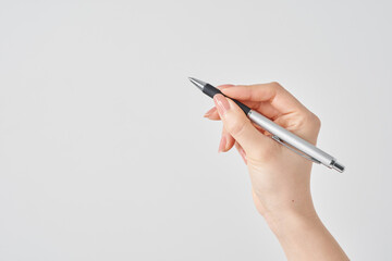 黒いボールペンを持つ女性の手と白い背景