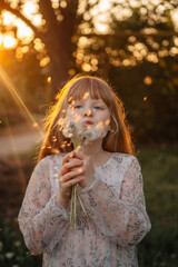 children's photo session with dandelions and a butterfly at sunset