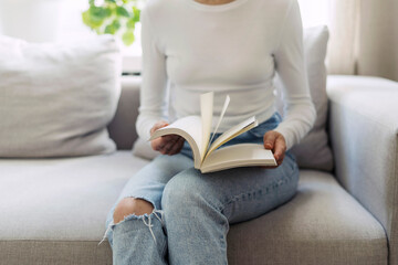 Cropped shot of woman hold paper notebook in hands while sitting on couch