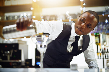 Black man, bartender and prepare alcohol in restaurant, hospitality and counter server for martini....