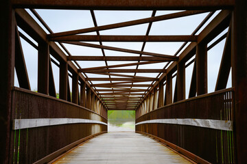 Old converted rustic railroad pedestrian foot bridge along the Big Sioux River Urban Green Way in...
