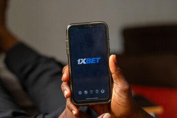 Fototapeta premium FCT Abuja, Nigeria - May 8 2024: 1xBet betting app logo on the display mobile phone