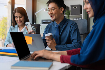 Businessmen write project ideas and use laptops to edit papers for brainstorming sessions with partners in the office.