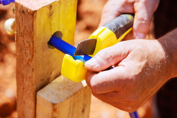 Water piping is cut with saw tool by plumber using blue plastic PVC water piping