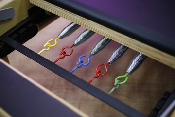 
Closeup of reformer pilates stretcher springs. Metal springs with colored tips according to their...
