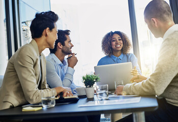 Business people, laptop and collaboration with team in meeting for discussion or development at office. Group of happy employees discussing company strategy, financial growth or revenue at workplace