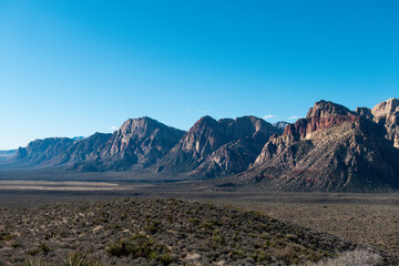 Panoramic shot of the stunning Red Rock Canyon National Conservation Area with desert vegetation and surrounding mountains on a sunny day - Nevada, USA