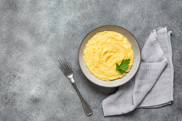 Mashed potatoes in a bowl on a gray rustic background. Top view, copy space.