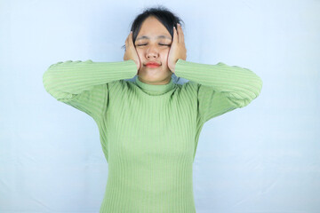 Asian woman suffering from headache desperate and stressed because pain and migraine. Hands on head.