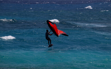 Surfer with a wing foil in the waves of the Caribbean Sea, Lac Cai, Bonaire, Caribbean Netherlands