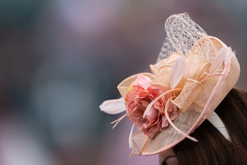A pink lace rose hat seen at a horse race