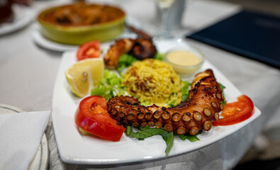 Grilled octopus tentacles with rice and vegetables.