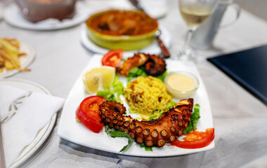 Grilled octopus tentacles with rice and vegetables.