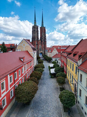 Drone photo of Katedra św. Jana Chrzciciela church in Wrocław in the summer with leading line (road) © Tymon