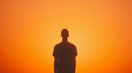 Silhouette of a man against a vivid orange sunset