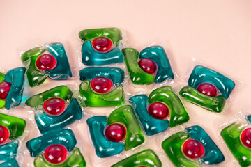 Laundry capsules on beige background close-up