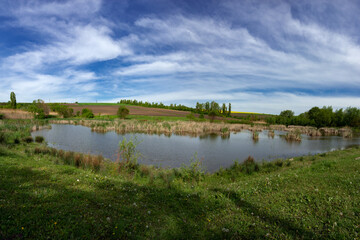Fishing grounds. Inland reservoir. The countryside is a comfort zone.Panorama of the outskirts of the village. Hanging clouds over the lake.