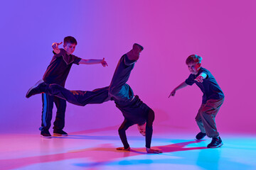 Dance battles. Dancer performing impressive headstand, breakdance moves mixed neon light against...