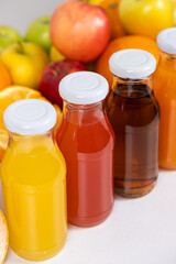 Different types of fruit juices - orange, grapefruit, apple and multifruit in glass bottles.