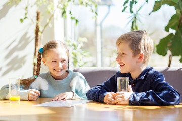 Smiling Children Reading Menu at Brightly Lit Table