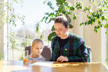 Mother and Daughter Reviewing Menu Together at Sunlit Table Surrounded by Indoor Plants